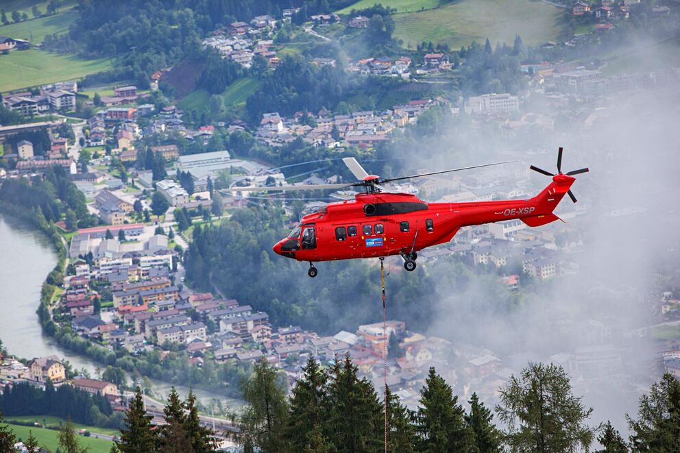Roter Helikopter im Einsatz über einer Stadt