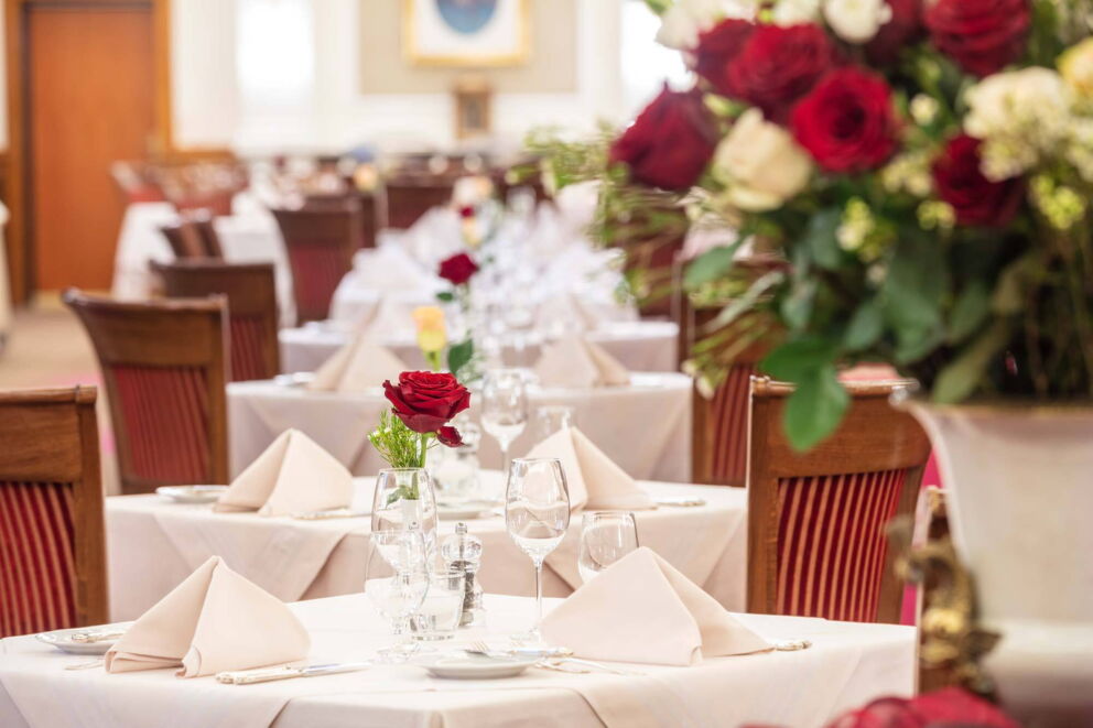 Schon gedeckte Tische dekoriert mit einer Rose im Restaurant im Hotel Stefanie