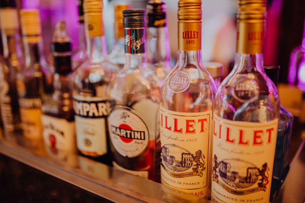 Verschiedene Alkoholflaschen die nebeneinander stehen von Lillet bis zu Martini