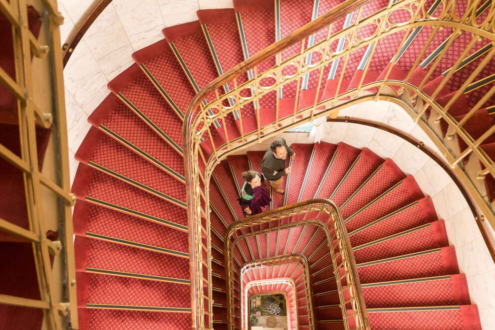 Ein Pärchen im Wendeltreppen förmigen Treppenhaus im Hotel Erzherzog Rainer
