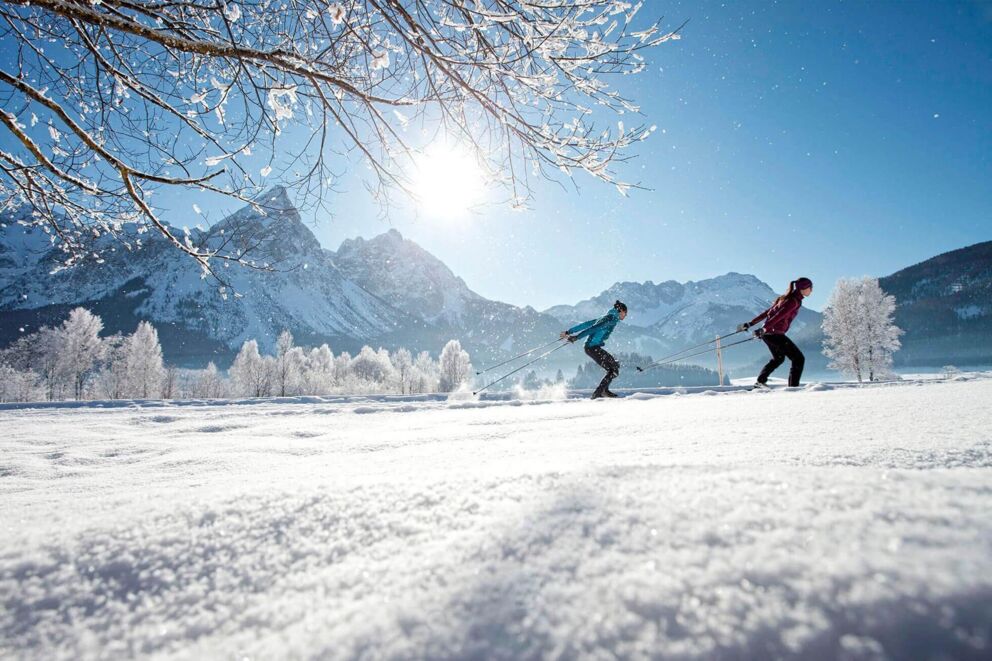 Sportliche Frauen beim Langlaufen in österreichischer Winterlandschaft