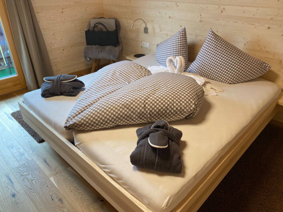Liebevolles hergerichtet Bett am Panoramagasthof Kristberg mit gefalteten Handtuchschwänen