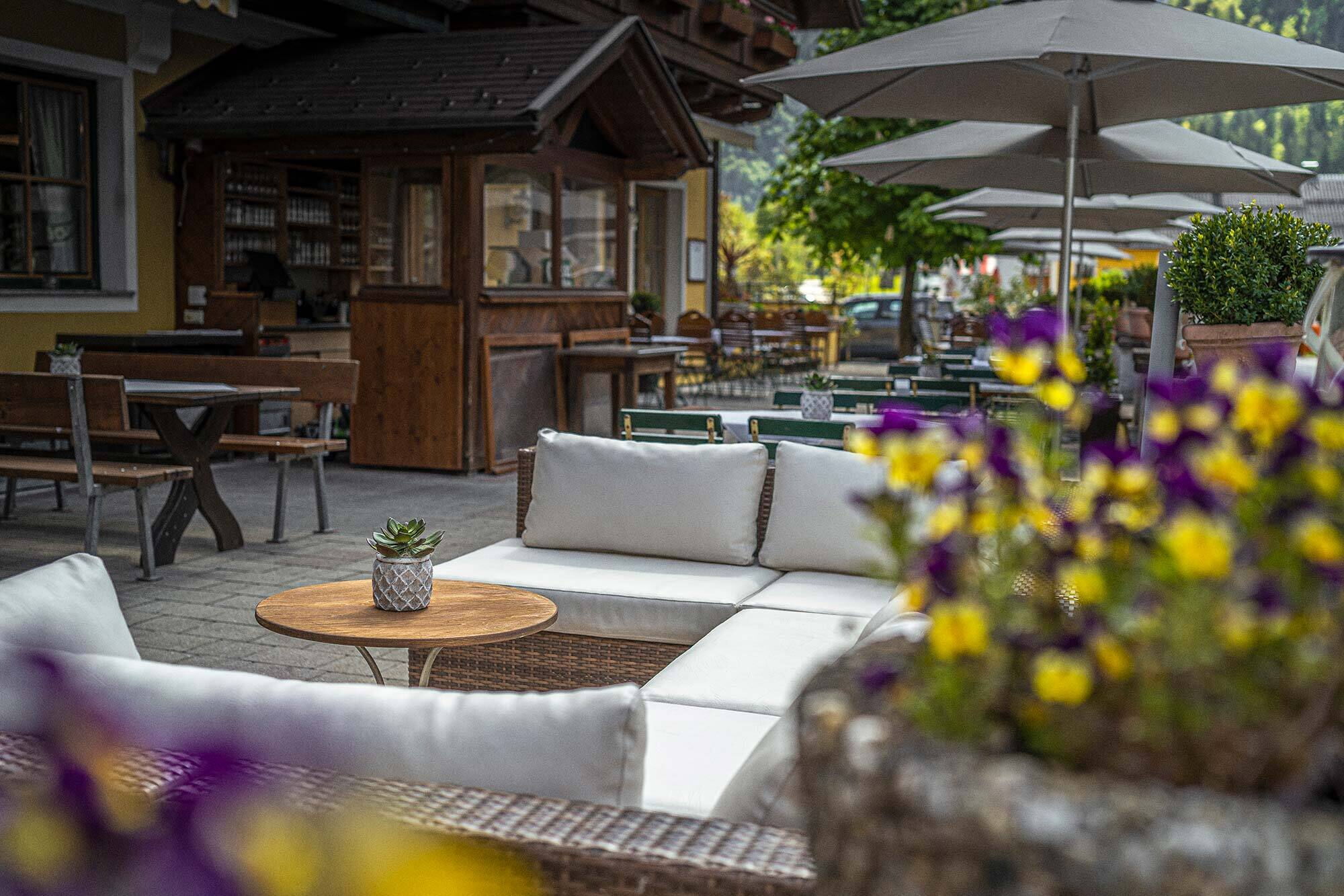 Gemütlicher bepflanzte Gastgarten mit bequemem Gartensofa