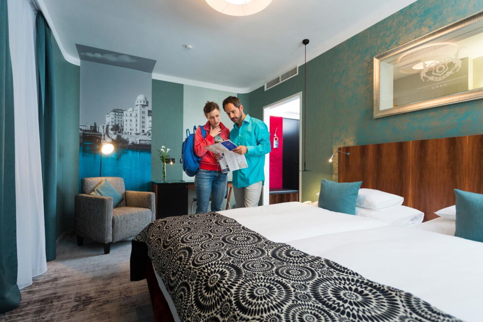 Pärchen mit Stadtplan in einem modernen und gemütlich eingerichtetem Zimmer des Hotel Capricorno