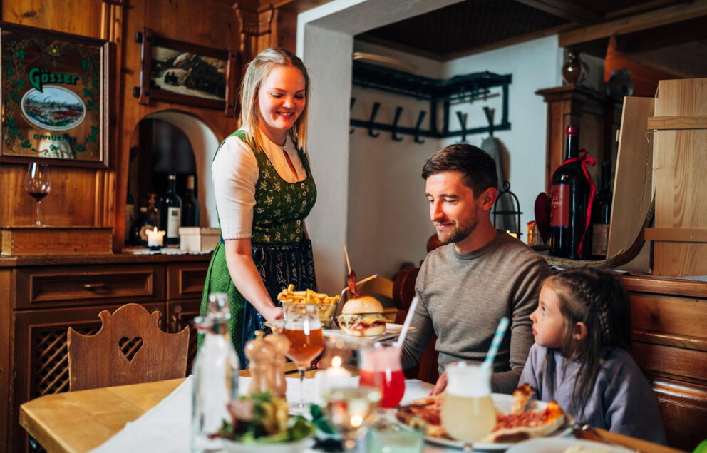 Vater und Kind bekommen Ihr Essen in der Trattler Einkehr serviert