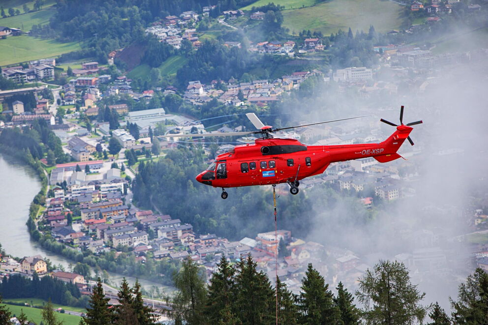 Roter Helikopter im Einsatz über einer Stadt