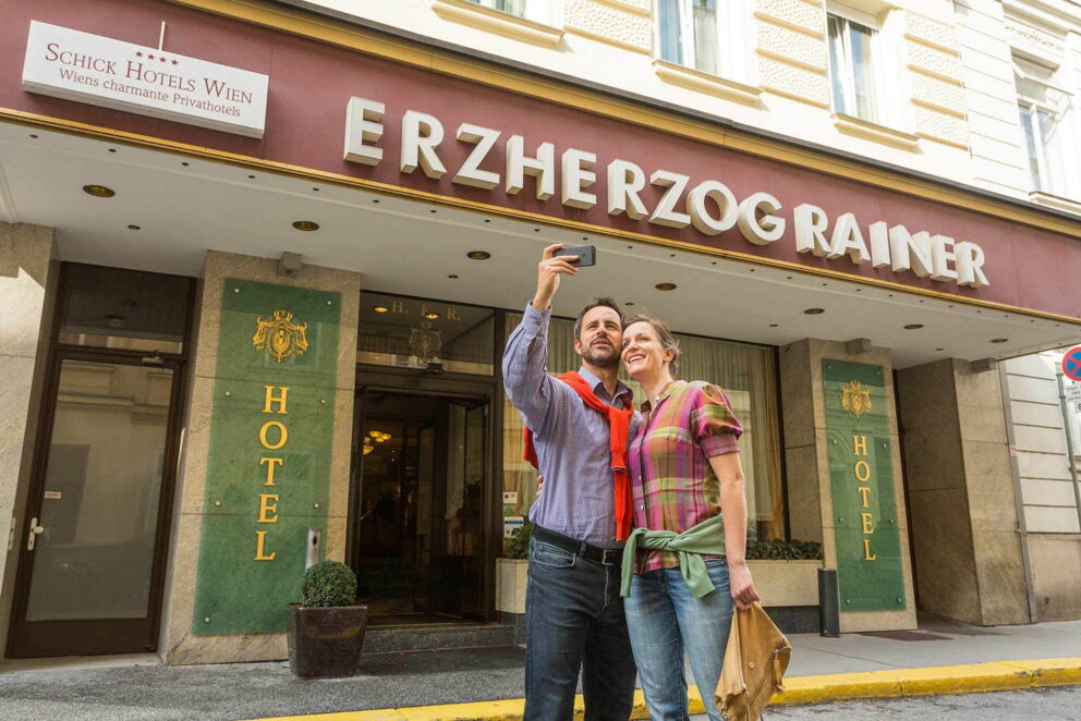 Pärchen fotografierend vor dem Hoteleingang des Hotel Erzherzog Rainer