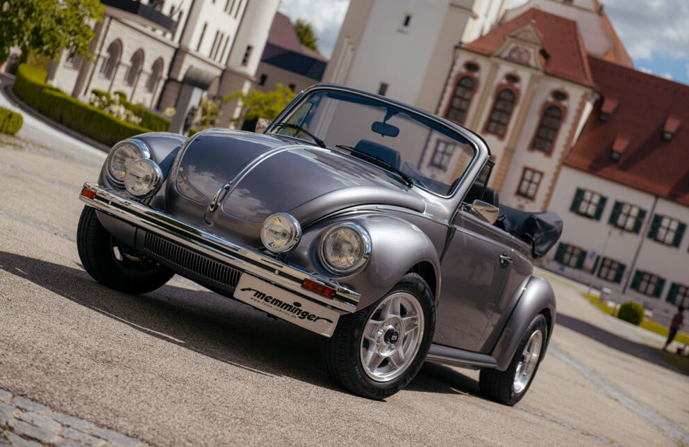 Exklusiver metallic farblicher Memminger VW Käfer auf einem Dorfplatz