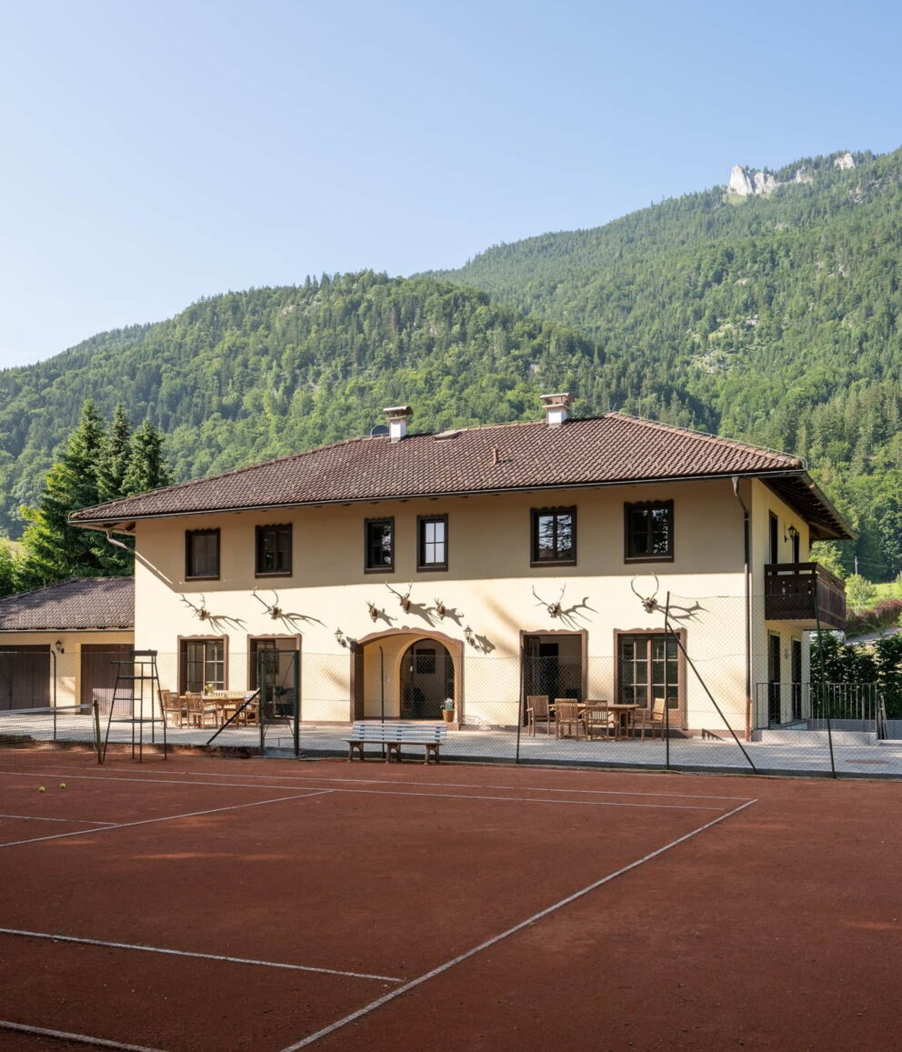 Das Promegggut in der Außenansicht mit dem Tennisplatz davor.