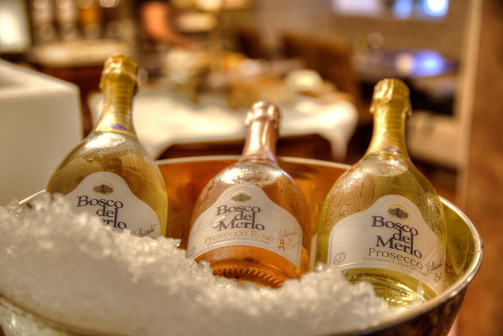 Ein Kübel mit Eis worin drei verschieden Flaschen Prosecco liegen