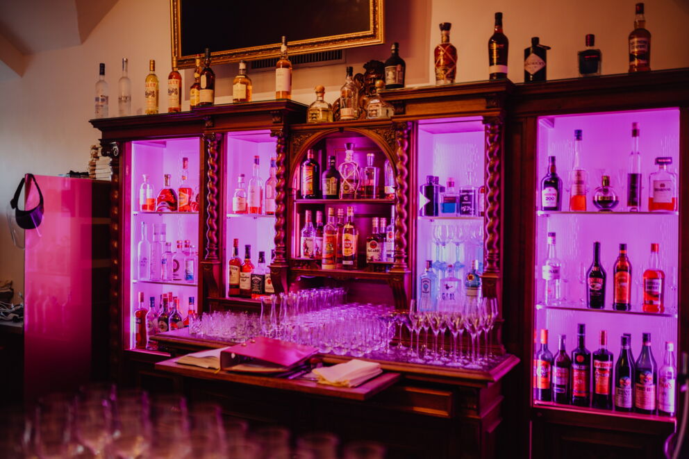 Ein Bild des Lila beleuchteten Schankraum der Castello Bar
