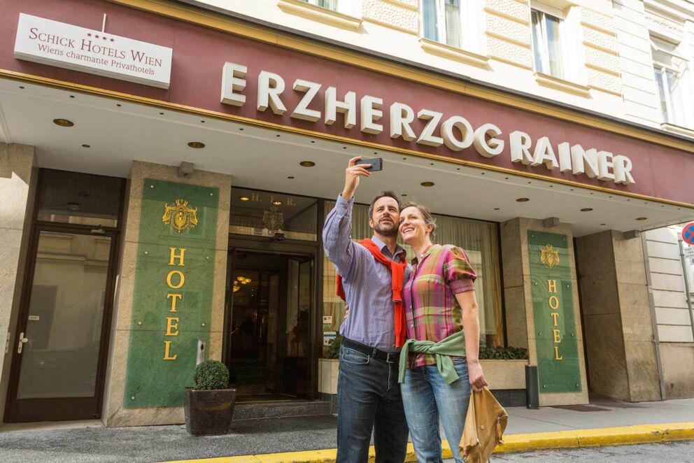 Pärchen fotografierend vor dem Hoteleingang des Hotel Erzherzog Rainer