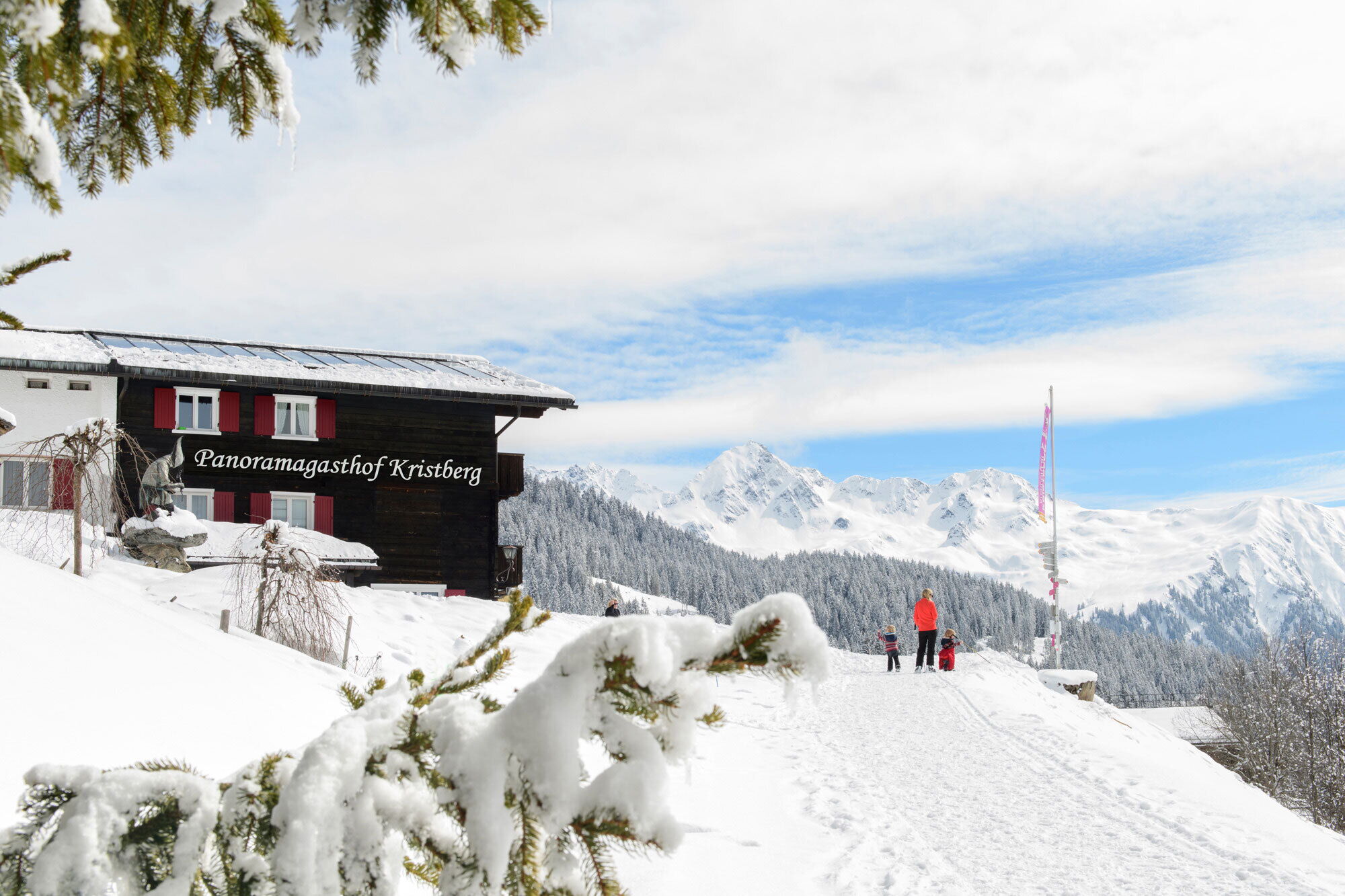 Verschneiter Panoramagasthof Kristberg mit Blick auf die Beschneite Berglandschaft