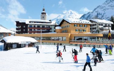 Skifahrer vor Hotel im Dorf